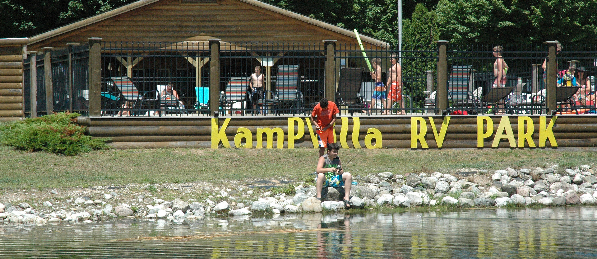Kampvilla Sign and pool behind it
